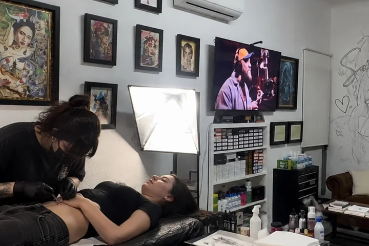 Profesional del tattoo trabajando con protección